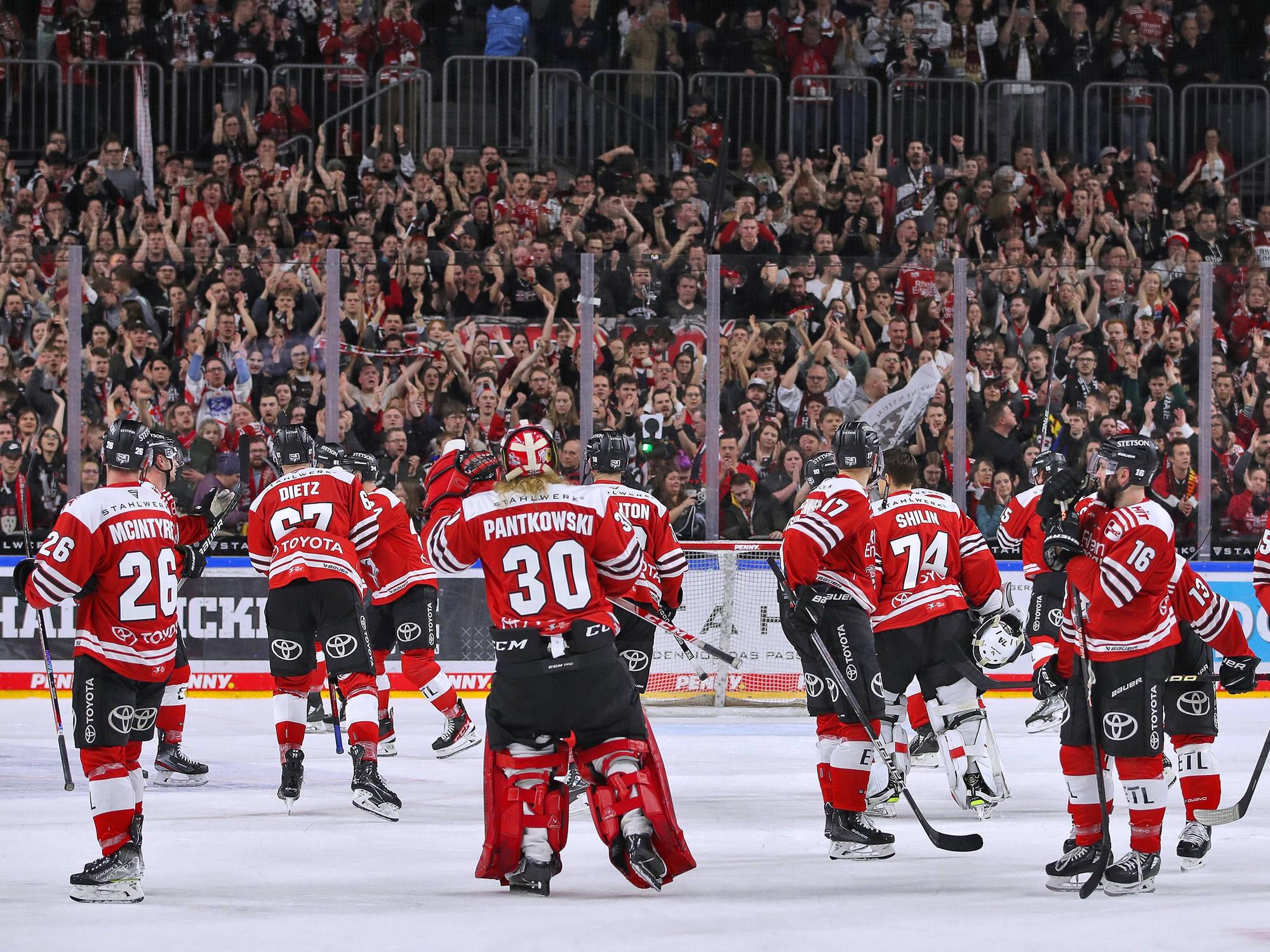 Die Spieler der Kölner Haie fahren über das Eis.