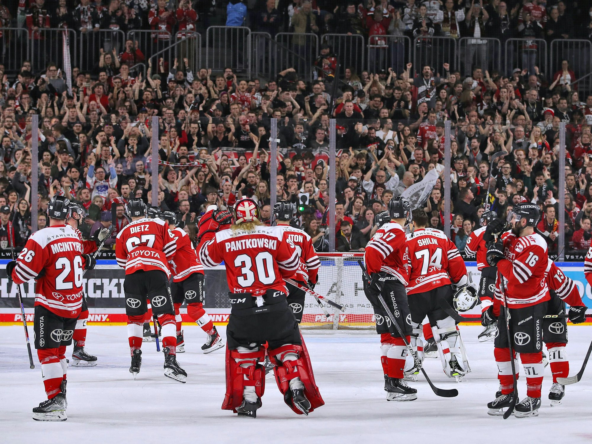 Die Spieler der Kölner Haie fahren über das Eis.