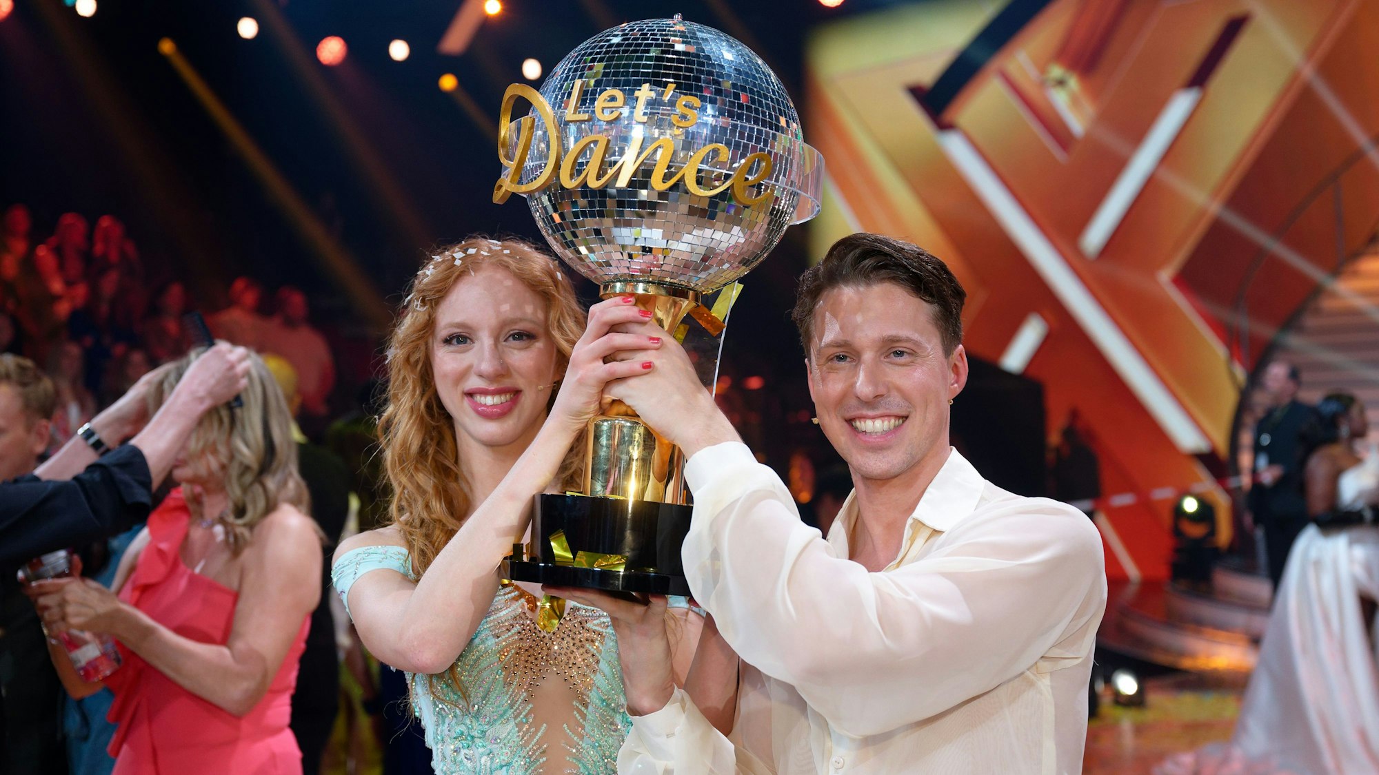 Anna Ermakova und Valentin Lusin jubeln über ihren Sieg mit der Trophäe nach dem Finale der RTL Live-Tanzshow „Let’s Dance“.