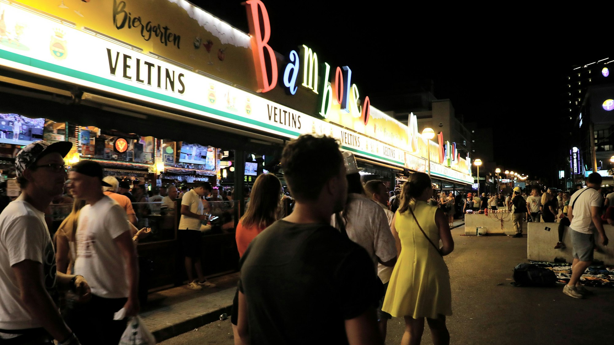 Spaziergänger und Spaziergängerinnen laufen in der Schinkenstraße am Strand von Arenal auf Mallorca.