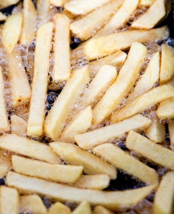 Pommes brutzeln in einer Fritteuse, hier im Juni 2020.