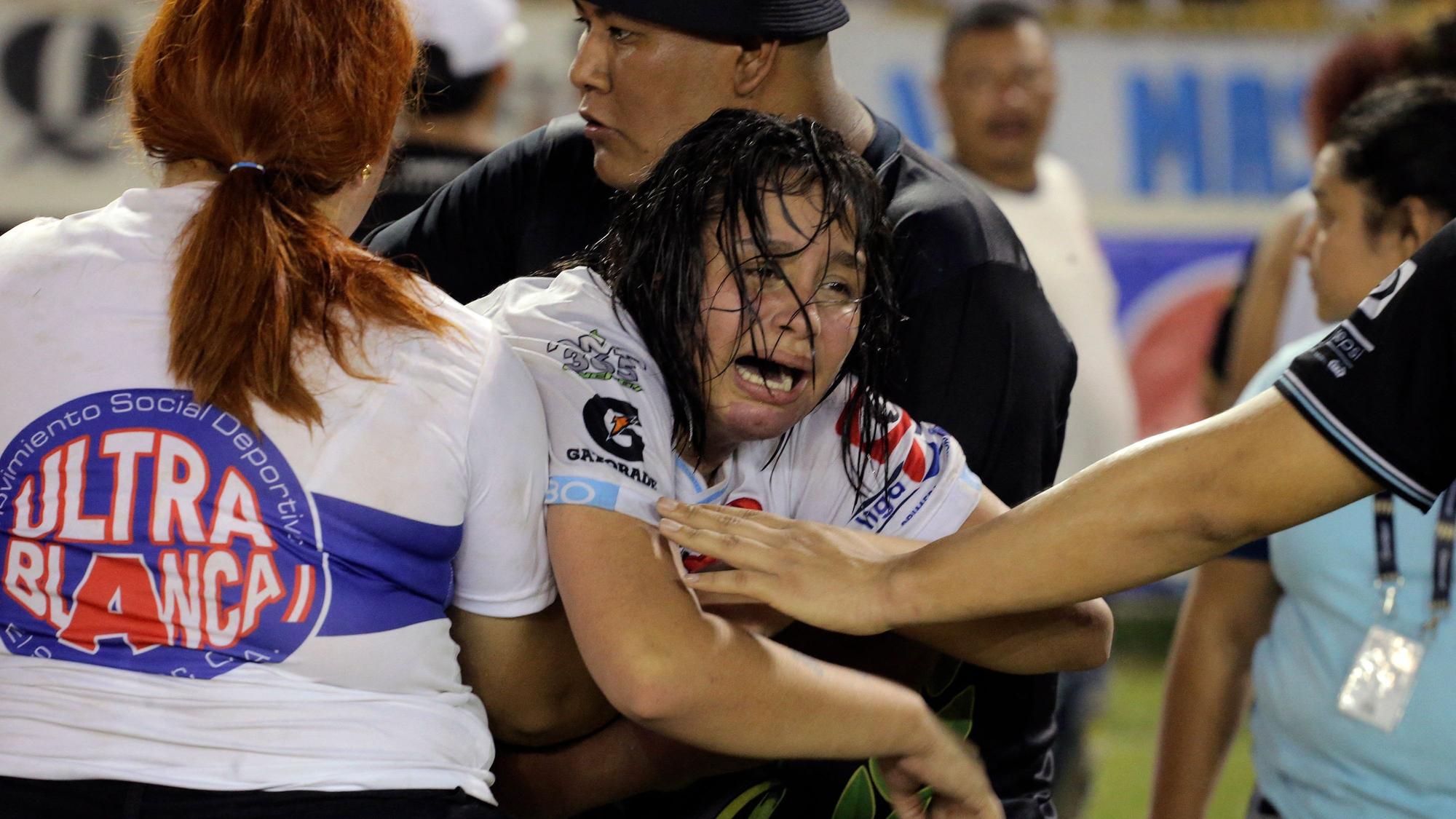 Eine Frau wird von anderen gehalten, während sie nach einer Massenpanik während eines Fußballspiels in San Salvador am 20. Mai 2023 weint.