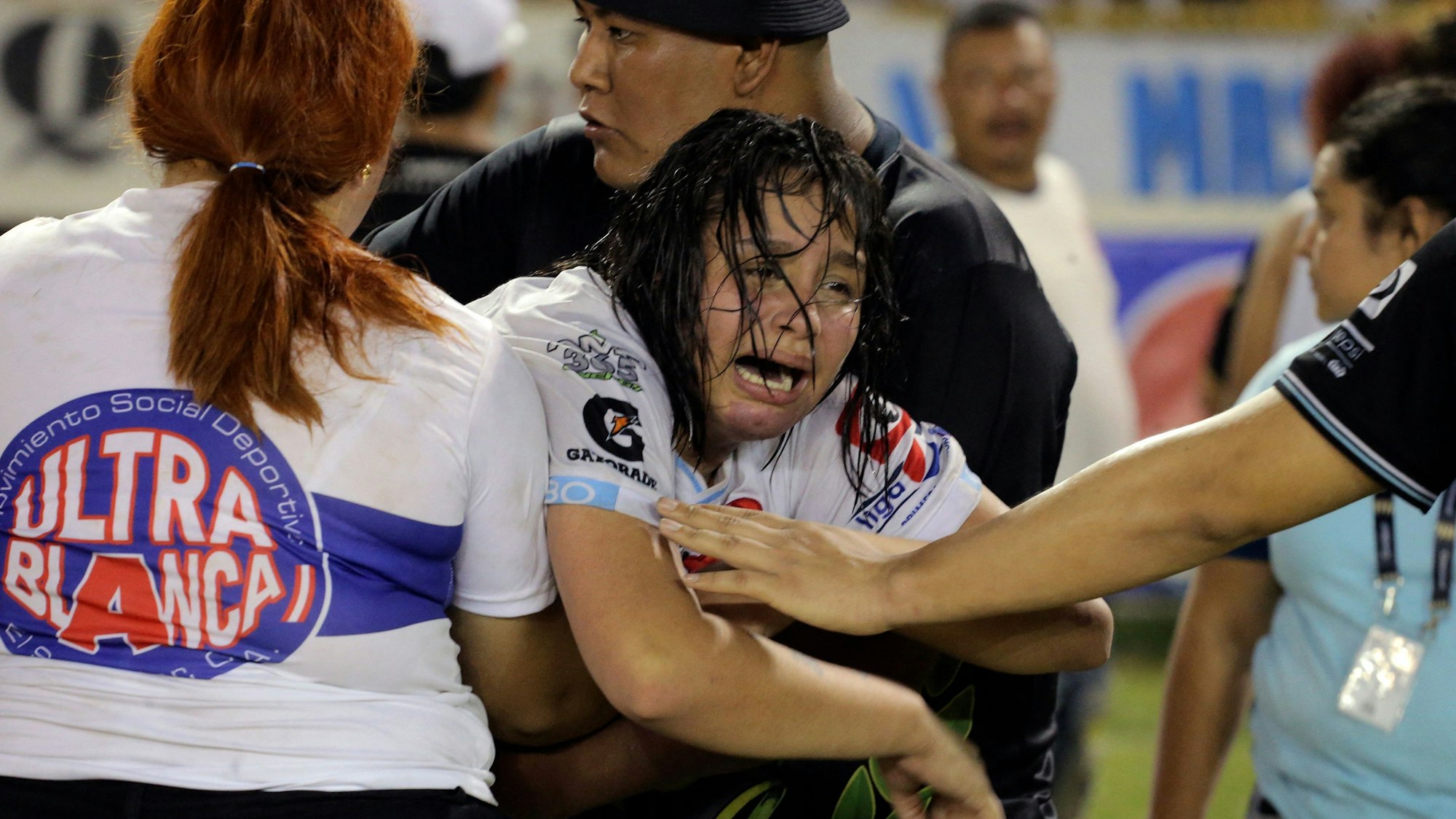 Eine Frau wird von anderen gehalten, während sie nach einer Massenpanik während eines Fußballspiels in San Salvador am 20. Mai 2023 weint.
