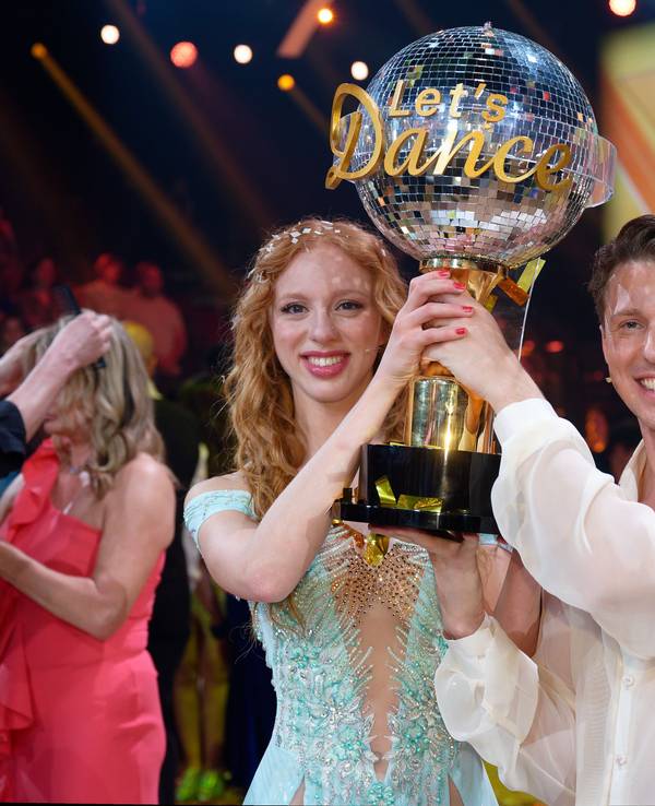 Model Anna Ermakova (l) und ihr Profi-Tanzpartner Valentin Lusin jubeln über ihren Sieg mit der Trophäe nach dem Finale der RTL Live-Tanzshow „Let's Dance“.