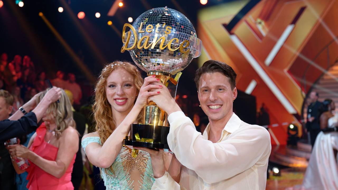 Model Anna Ermakova (l) und ihr Profi-Tanzpartner Valentin Lusin jubeln über ihren Sieg mit der Trophäe nach dem Finale der RTL Live-Tanzshow „Let's Dance“.