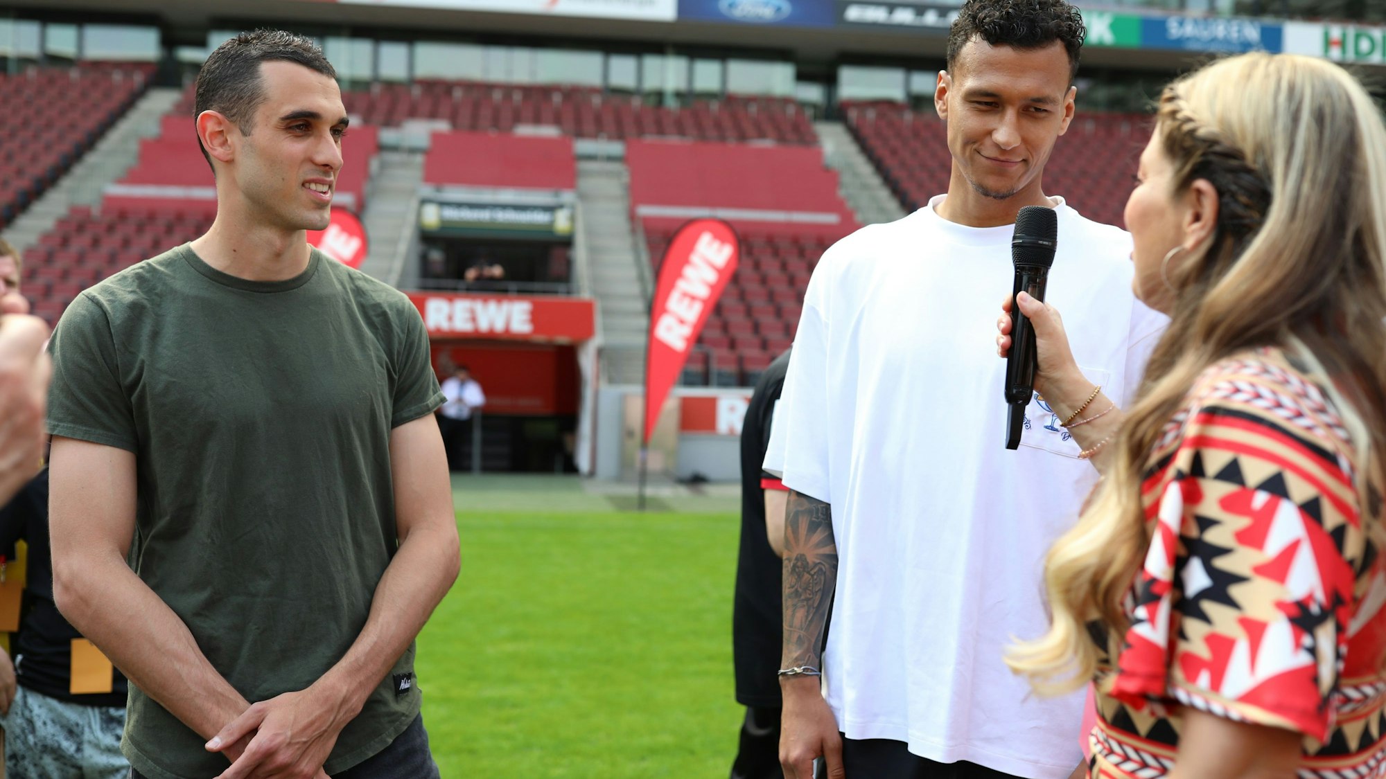 Zwei Fußballspieler werden von einer Moderatorin interviewt.