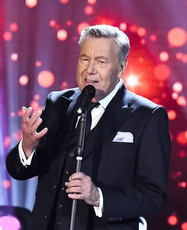 Roland Kaiser steht auf der Bühne und singt.