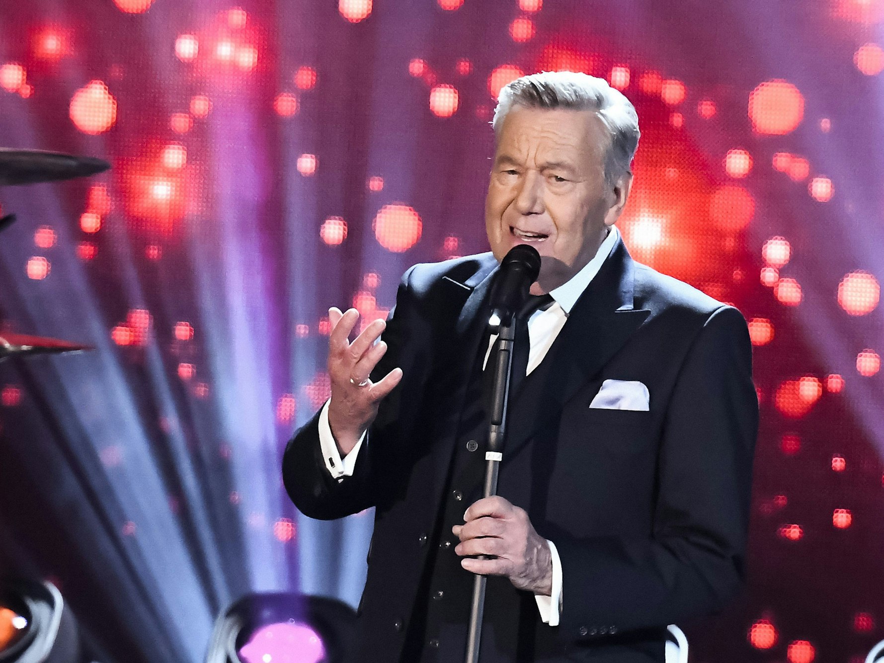 Roland Kaiser steht auf der Bühne und singt.