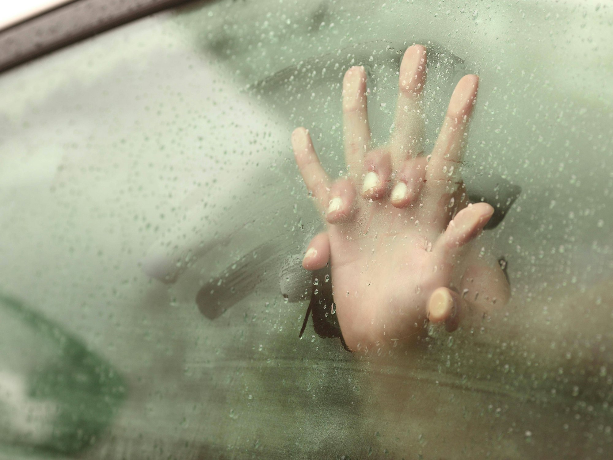 Ein Pärchen drückt seine Hände gegen eine Scheibe.