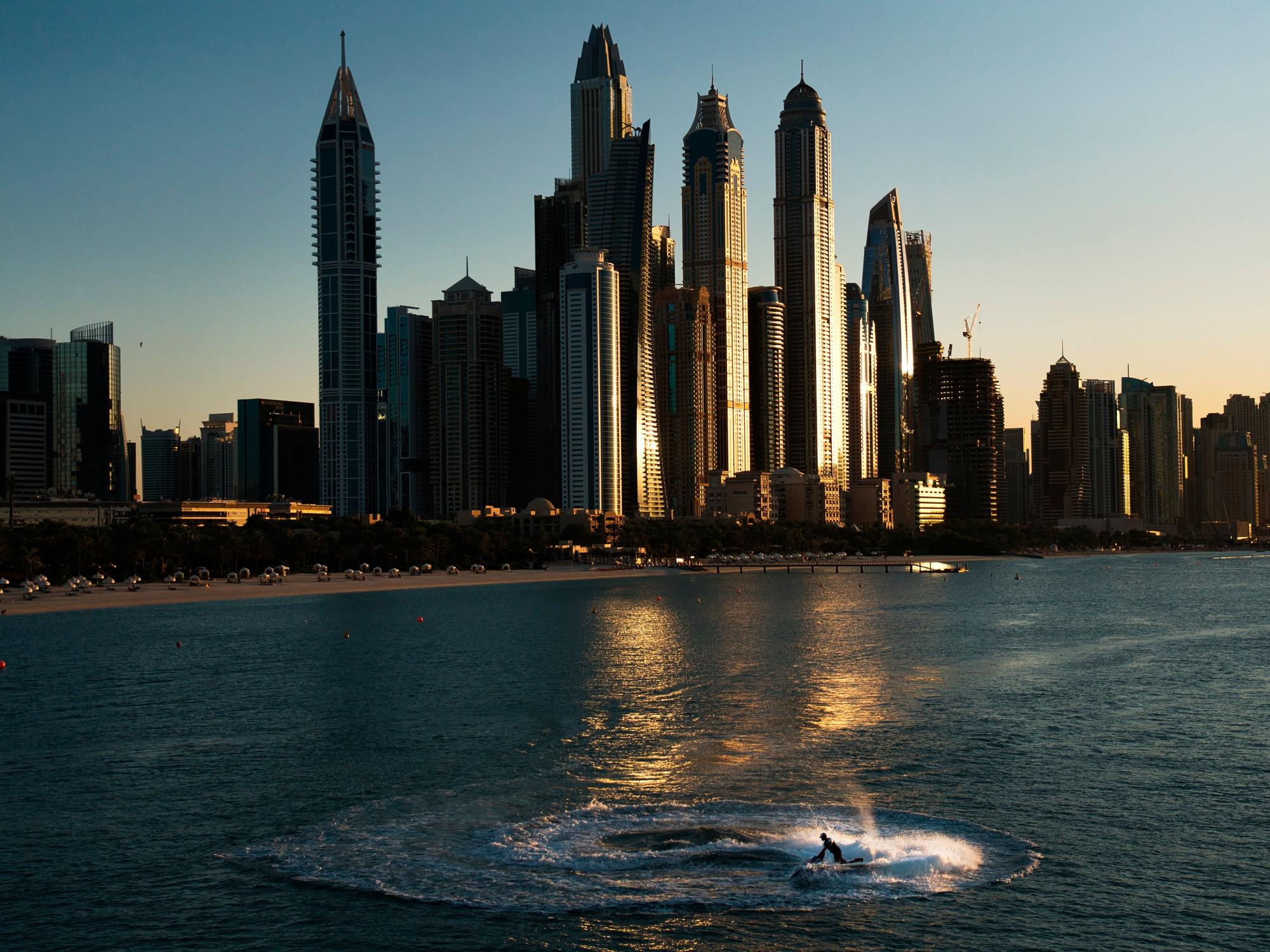 Ein Mann fährt einen Jet-Ski im Sonnenuntergang im Kreis vor der Küste von Dubai.