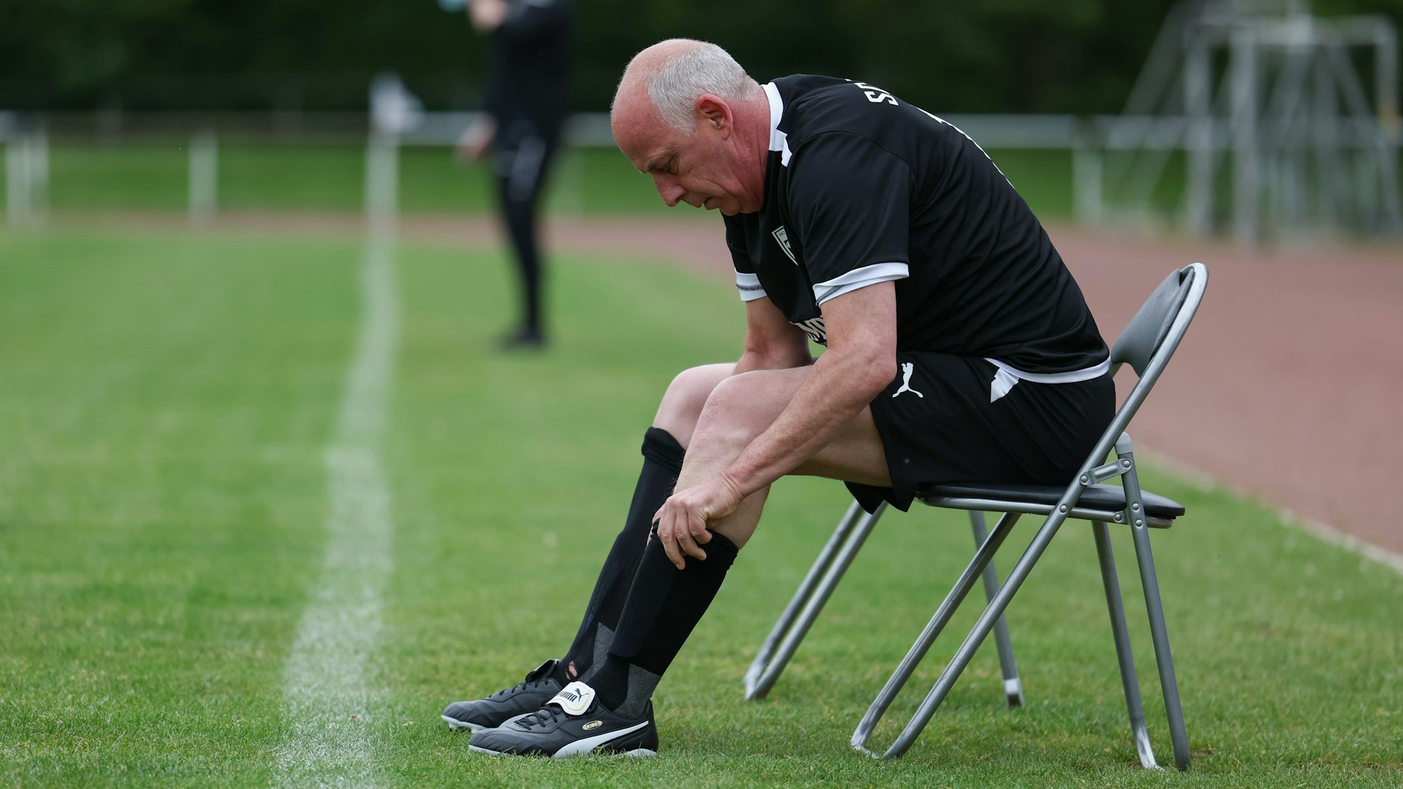 Der frühere Fußball-Nationalspieler Mario Basler zieht sich als Spielertrainer die Stutzen hoch.