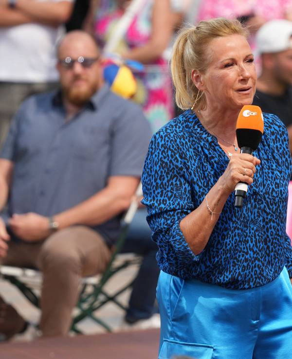 „Fernsehgarten“-Moderatorin Andrea steht im „Fernsehgarten“. Sie trägt ein blaues Oberteil und eine blaue Hose.