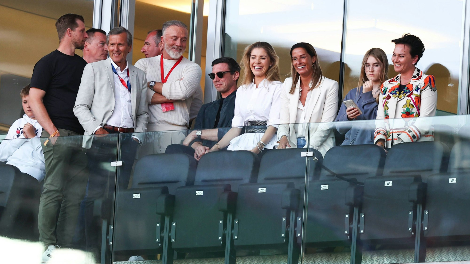 Victoria Swarovski (4.v.r.) und Mark Mateschitz sitzen Händchen haltend in der Red-Bull-Arena.