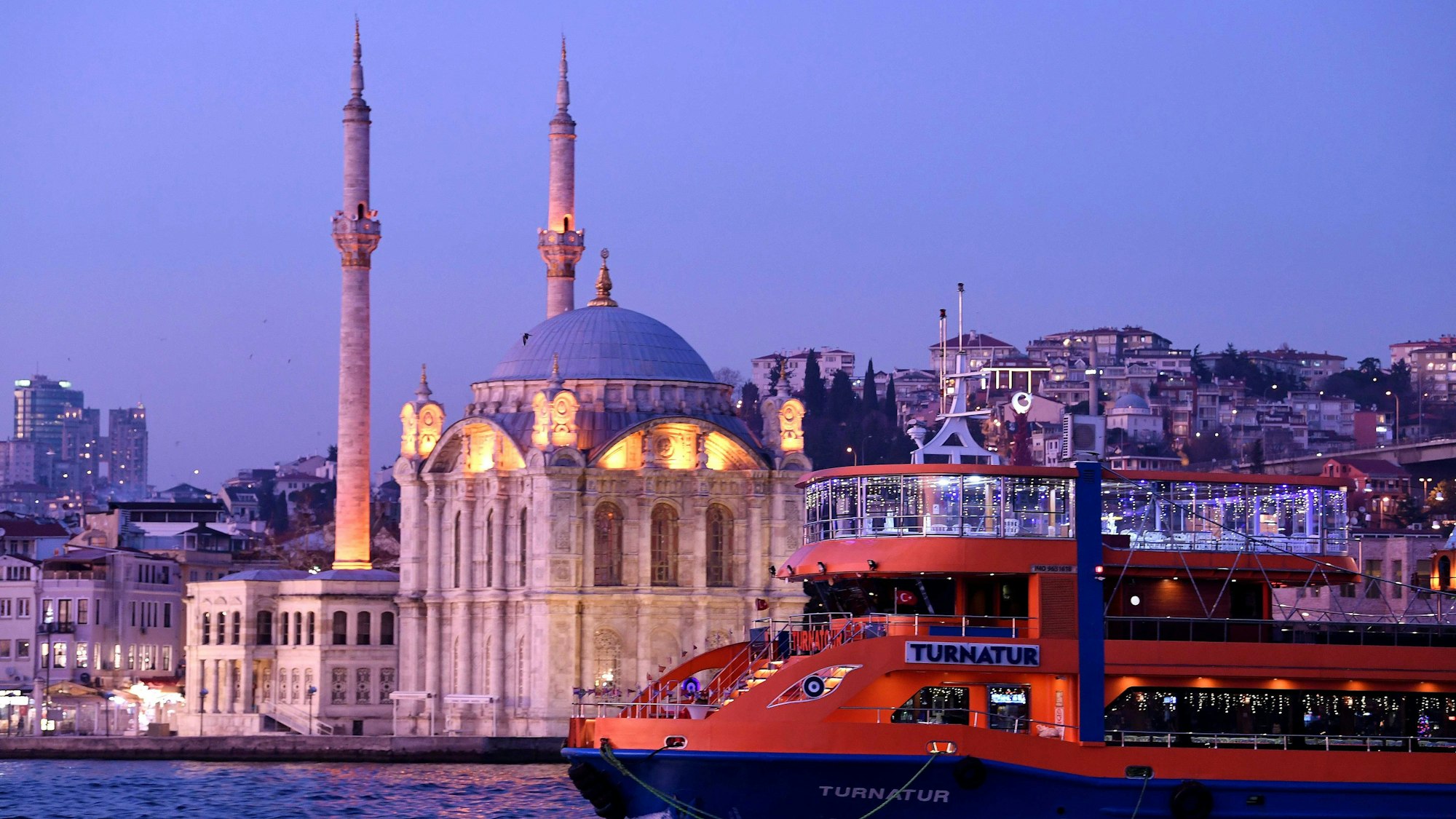 Passagiere sind bei Sonnenuntergang auf einer Fähre auf dem Bosporus unterwegs.