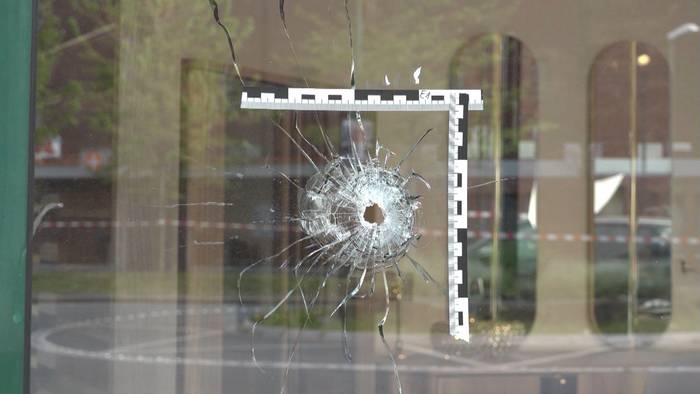 In einer Scheibe klafft ein Einschussloch, um das die Polizei eine Markierung angebracht hat.