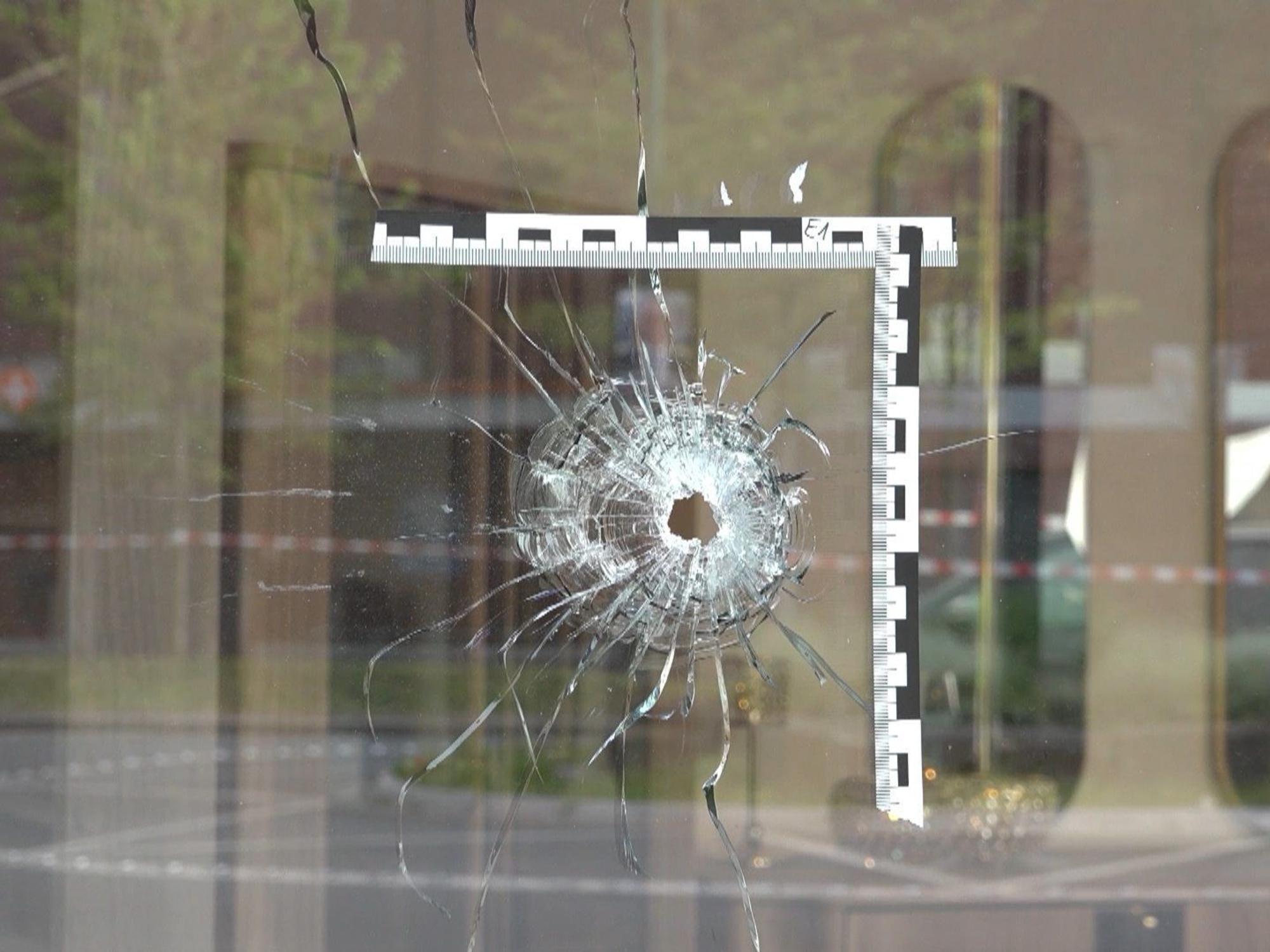 In einer Scheibe klafft ein Einschussloch, um das die Polizei eine Markierung angebracht hat.