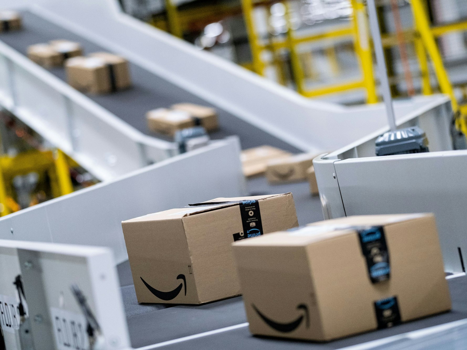 Pakete des Paketversenders Amazon laufen im Sortierzentrum über die Bänder.