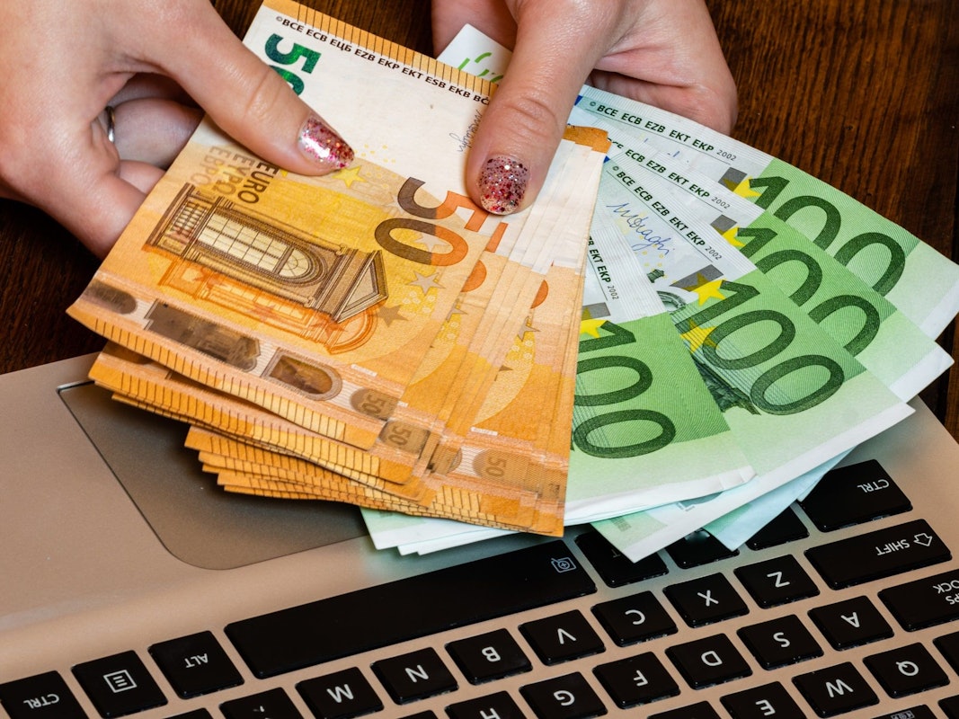 Hand hält Geldscheine.