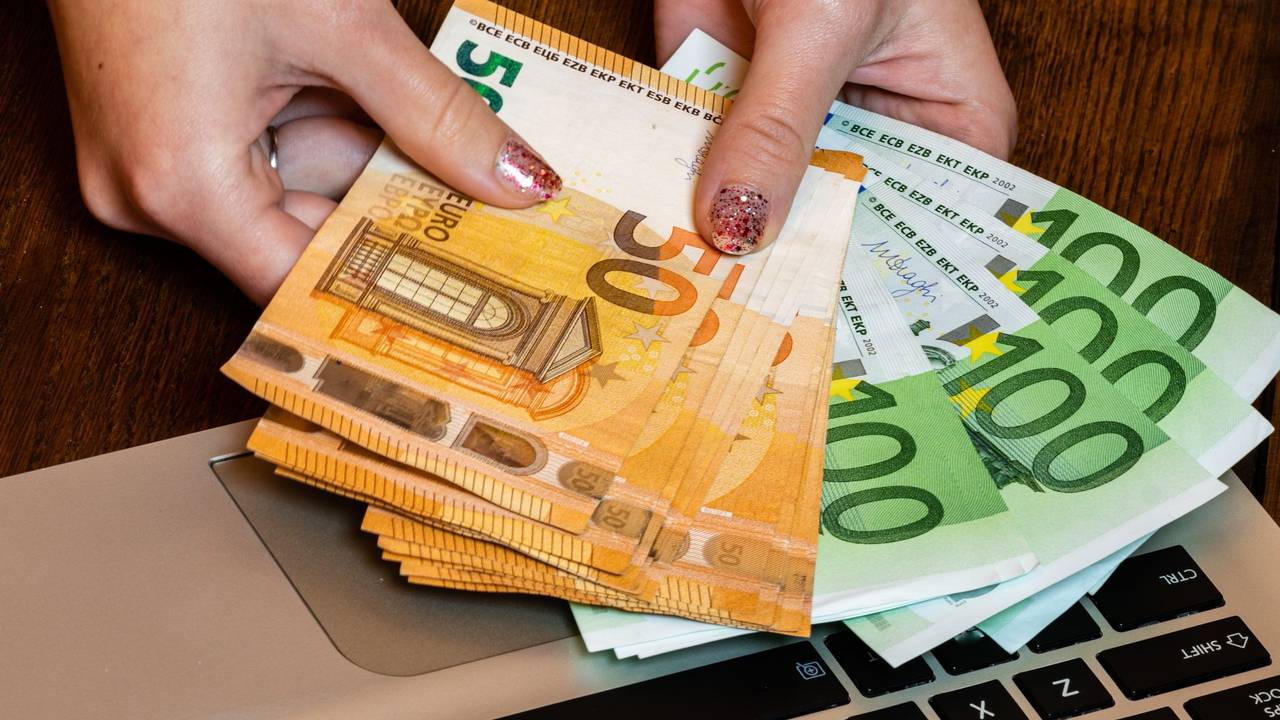 Hand hält Geldscheine.