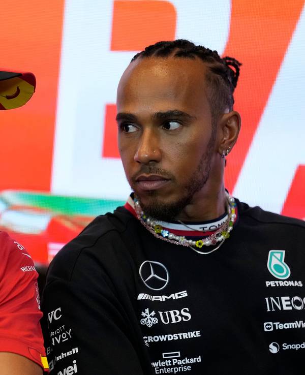 Carlos Sainz (l) aus Spanien vom Team Scuderia Ferrari unterhält sich mit Lewis Hamilton aus Großbritannien vom Team Mercedes-AMG Petronas Motorsport während einer Pressekonferenz.