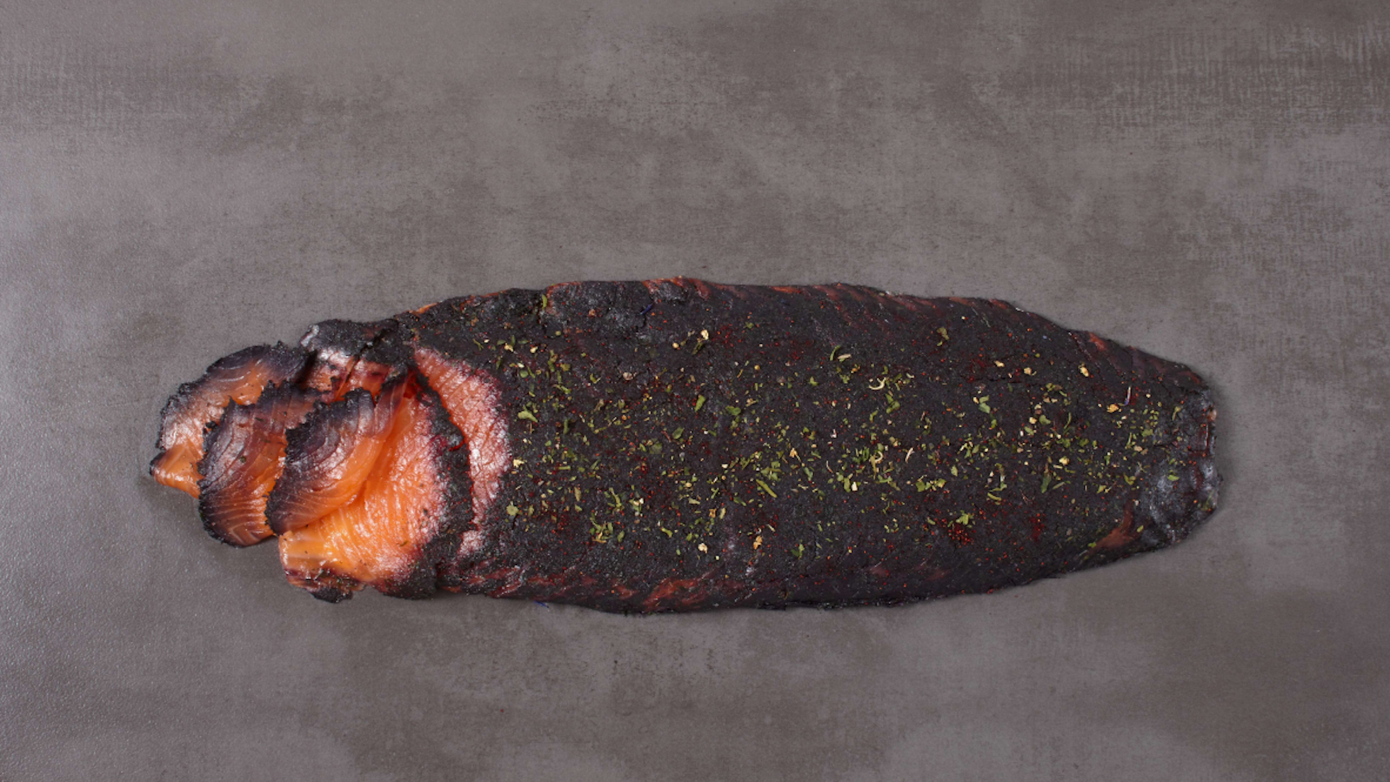 Ein Stück Lachs liegt auf einem Teller.