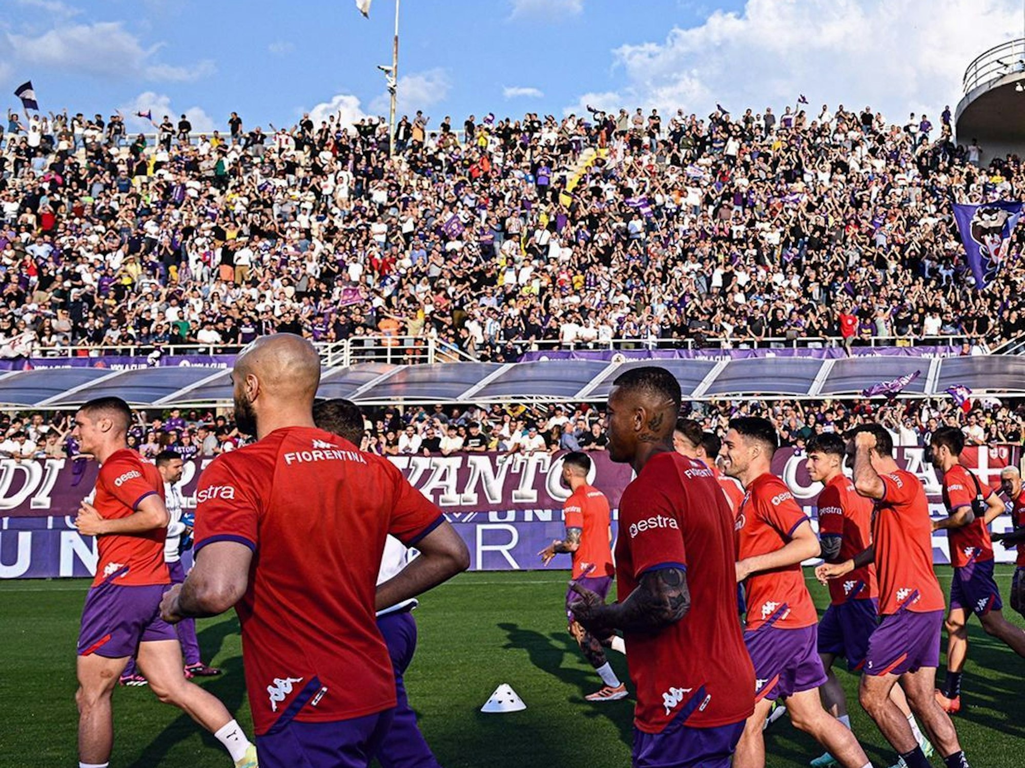 Die Spieler des AC Florenz laufen sich vor der Tribüne warm.