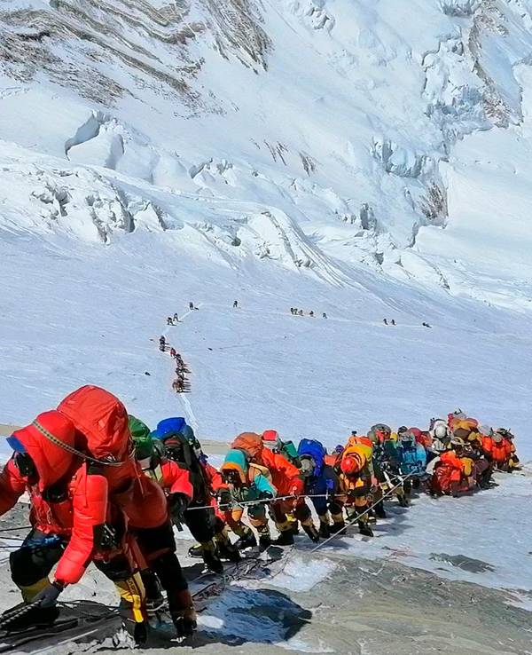 In einer langen Schlange klettern Bergsteigerinnen und Bergsteiger auf dem Mount Everest.