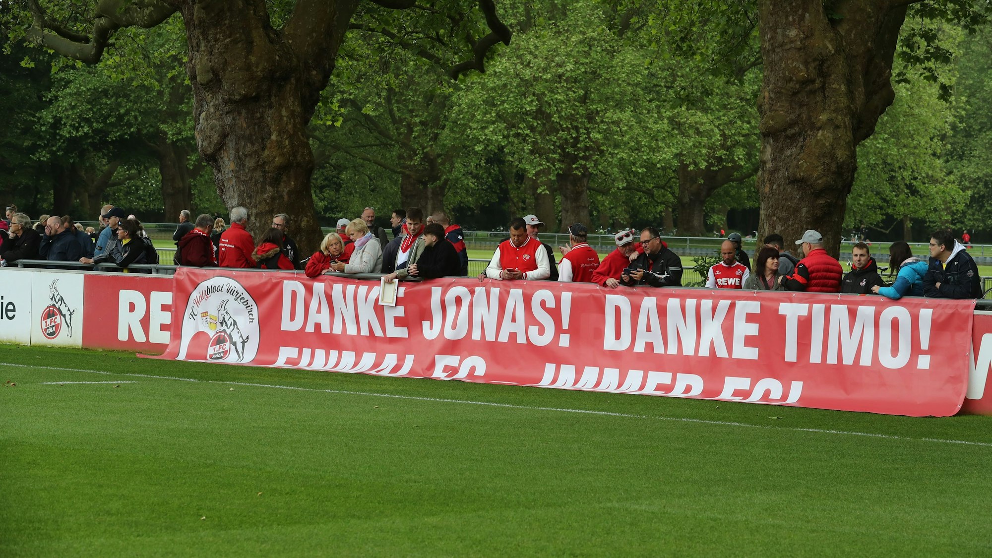 Beim Training des 1. FC Köln hängt ein Banner für Jonas Hector und Timo Horn an der Bande.
