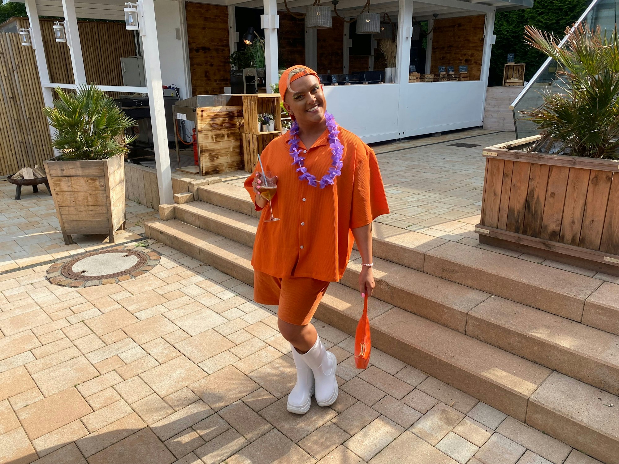 Influencer Twenty4Tim posiert im orangen Look