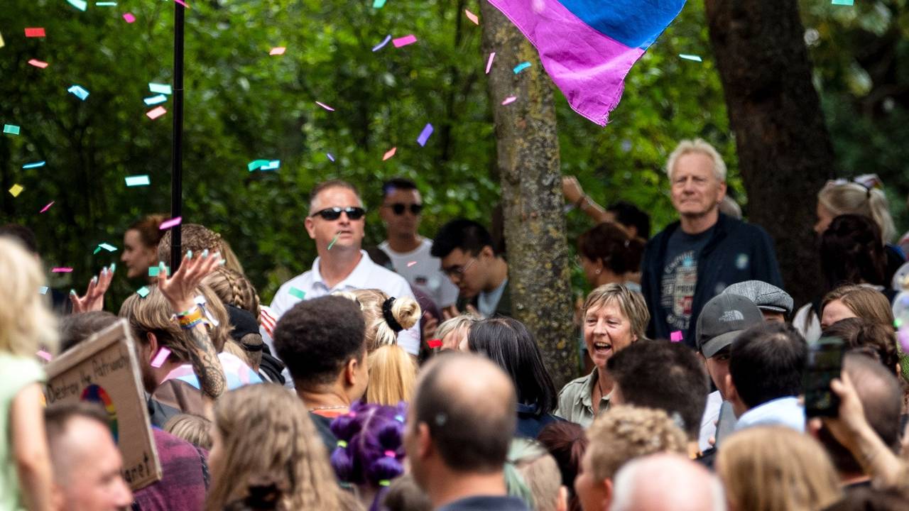 Teilnehmer ziehen beim Christopher Street Day (CSD) mit einer Regenbogenflagge durch die Innenstadt.