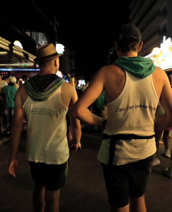 Vorwiegend junge Leute gehen am Abend des 1. Juli 2022 durch die Schinkenstraße im Party-Viertel Ballermann auf Mallorca.