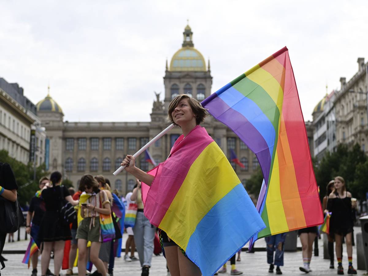 Eine Person trägt eine Regenbogenfahne und eine Pride-Fahne der Pansexuellen auf dem Prager Pride-Festival.