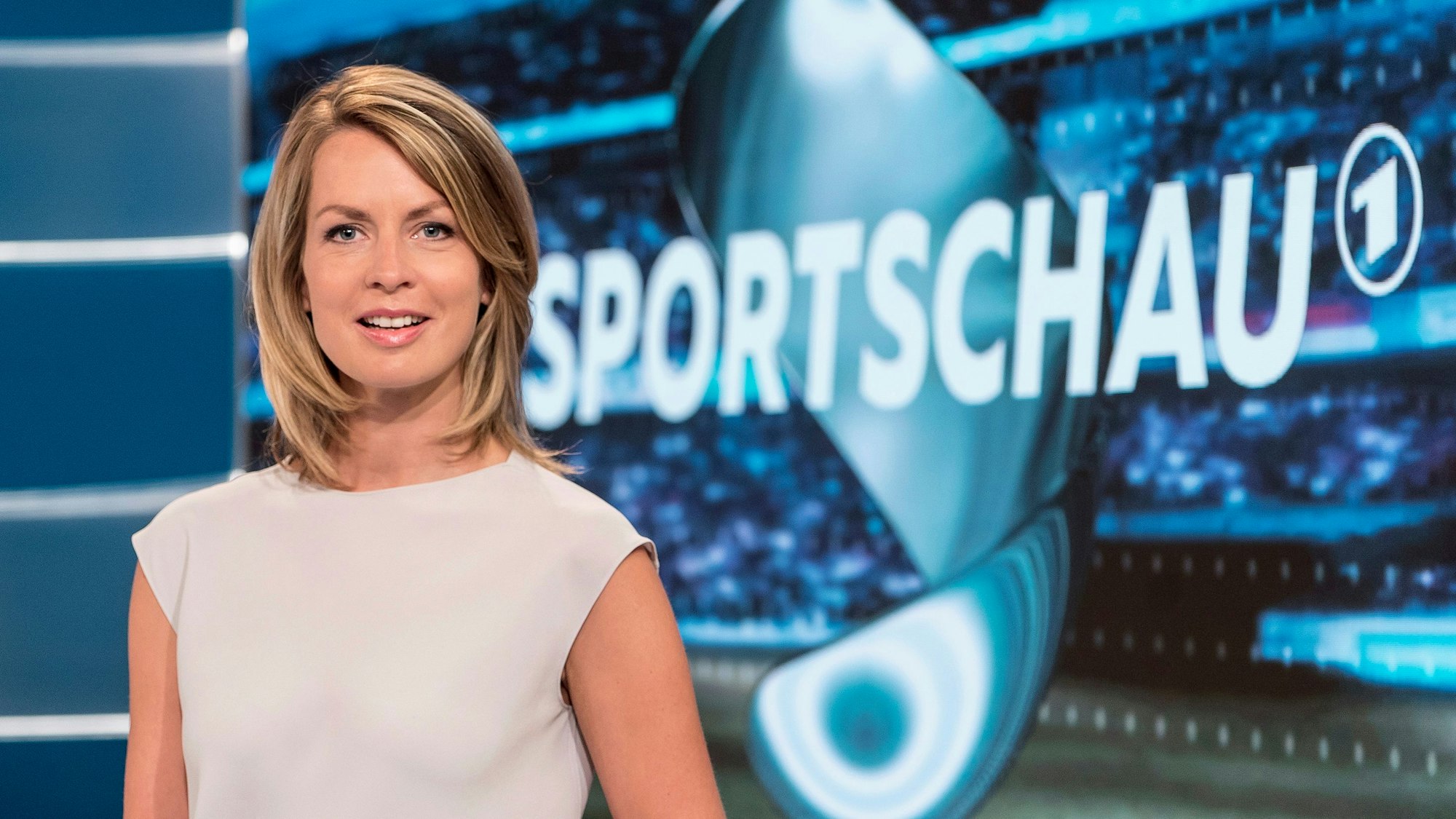 Jessy Wellmer im TV-Studio der ARD vor dem Logo der „Sportschau“.