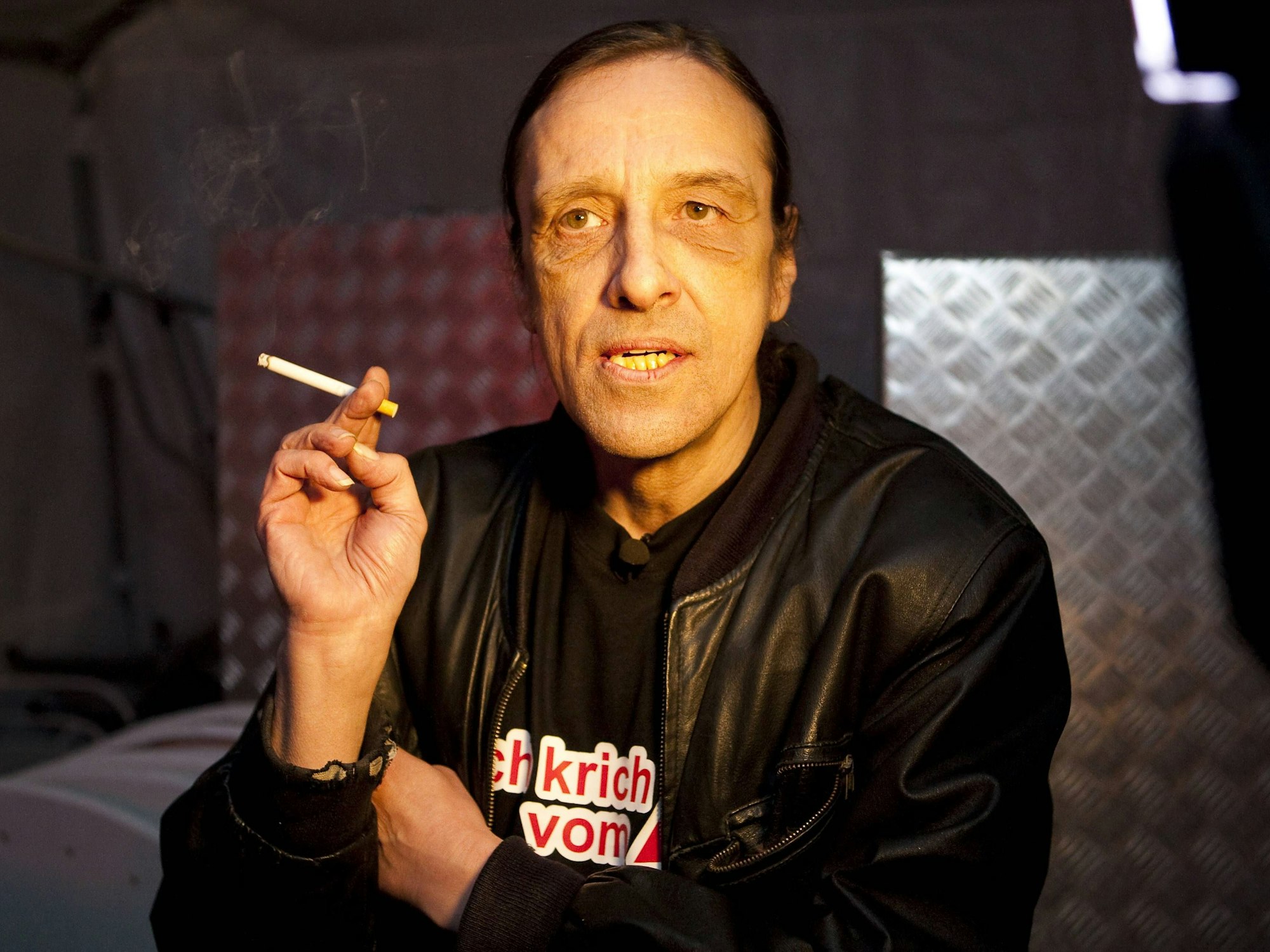 Arno Dübel raucht eine Zigartette.
