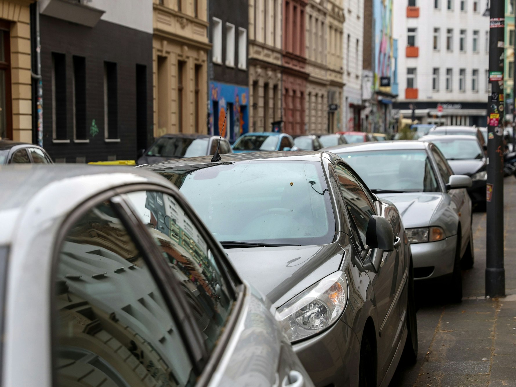 Autos parken in Köln auf einer Straße.