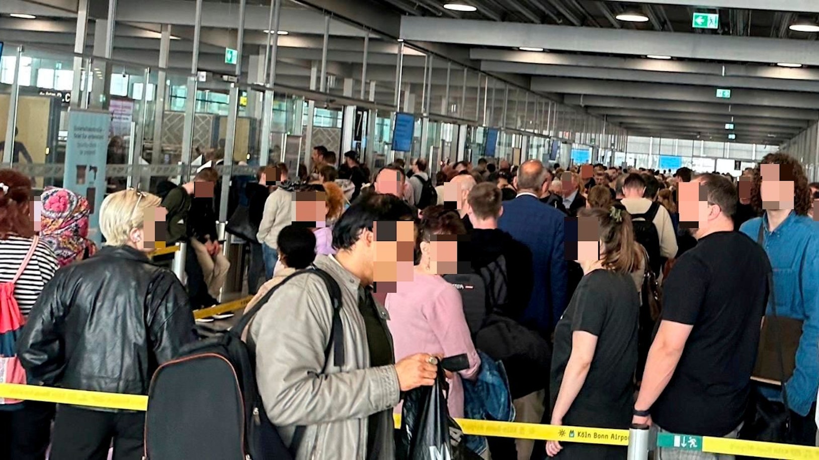 Eine Menschenmasse steht vor der Sicherheitskontrolle an.