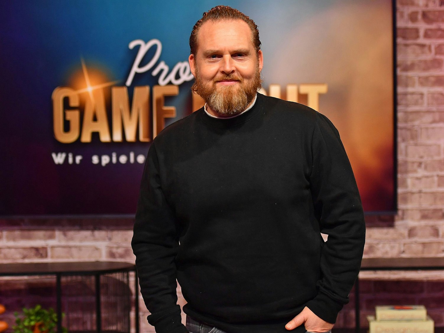 Schauspieler Axel Stein lächelt auf einem Pressefoto.