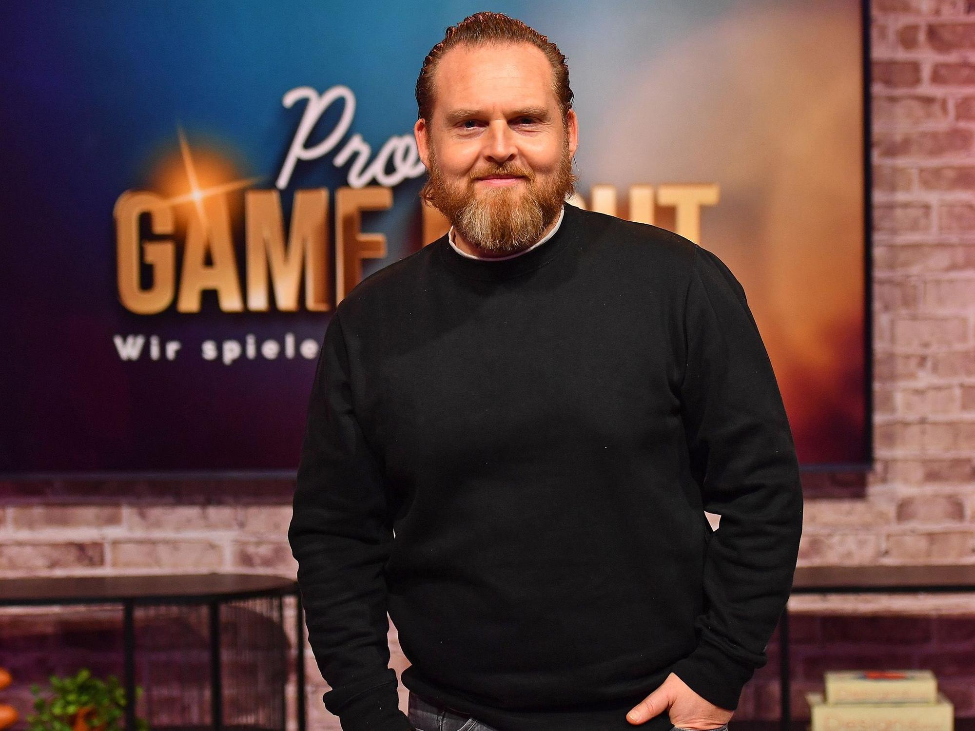 Schauspieler Axel Stein lächelt auf einem Pressefoto.
