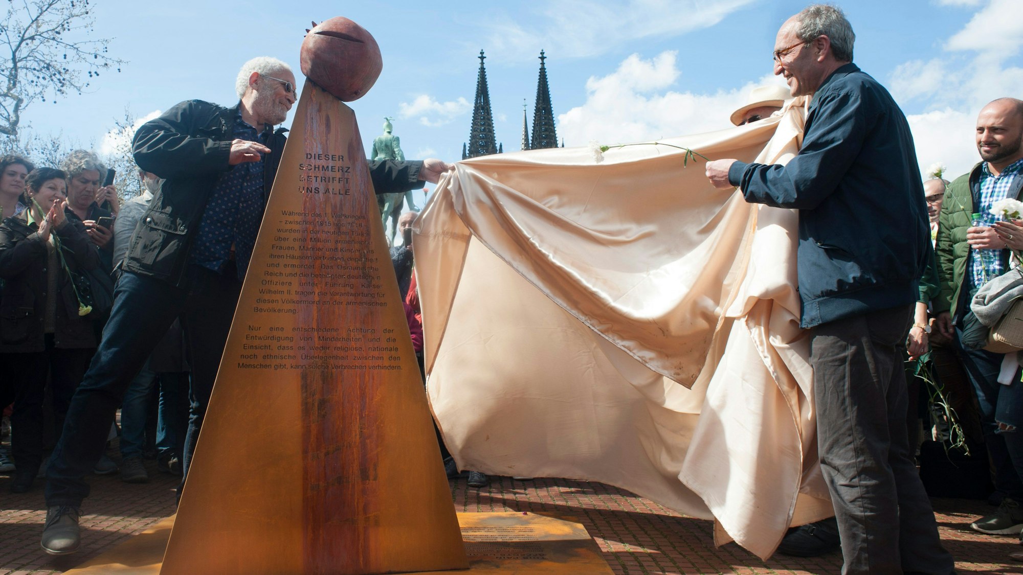 Zwei Männer enthüllen das Völkermord-Mahnmal.