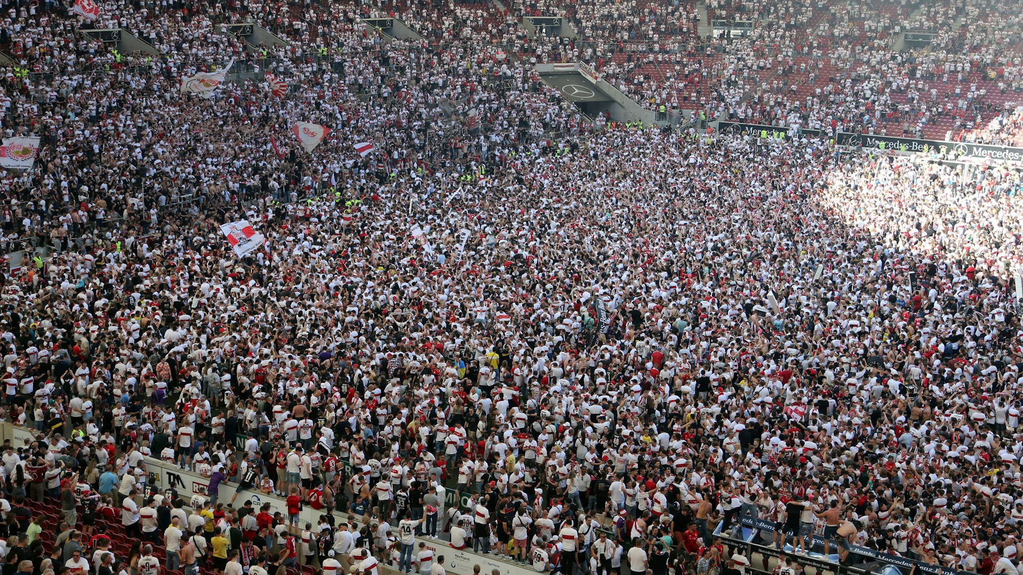 Die Fans des VfB Stuttgart feiern auf dem Spielfeld den Klassenerhalt.