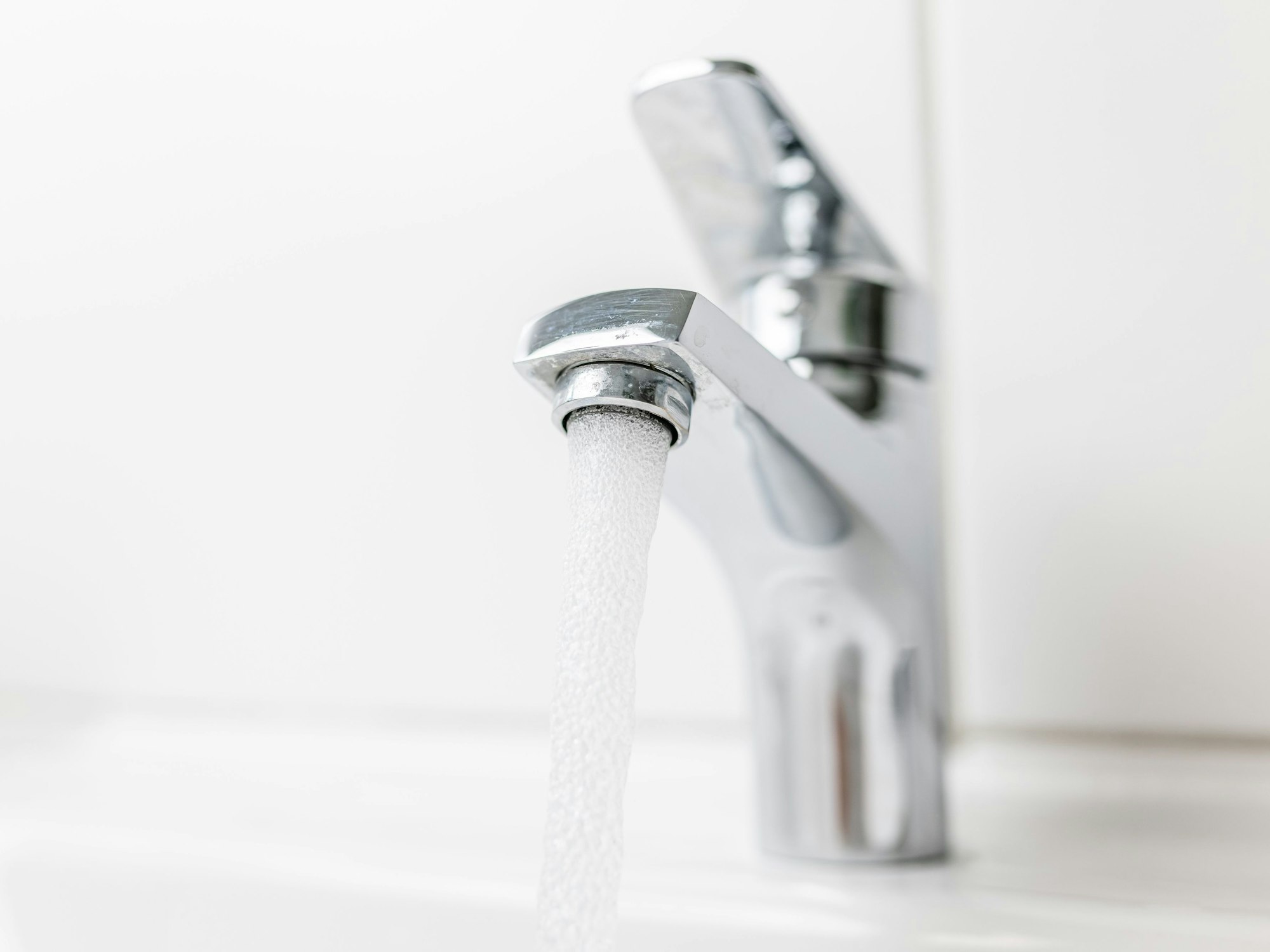 Leitungswasser fließt aus einem Hahn.