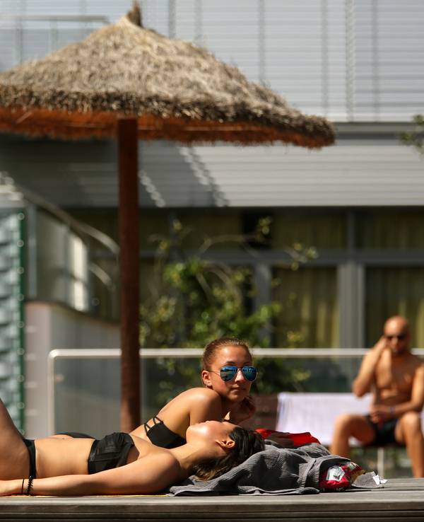 Zwei junge Frauen nehmen im Grugabad in Essen ein Sonnenbad (Archivbild 2016): Das Pfingstwochenende soll herrlich werden.