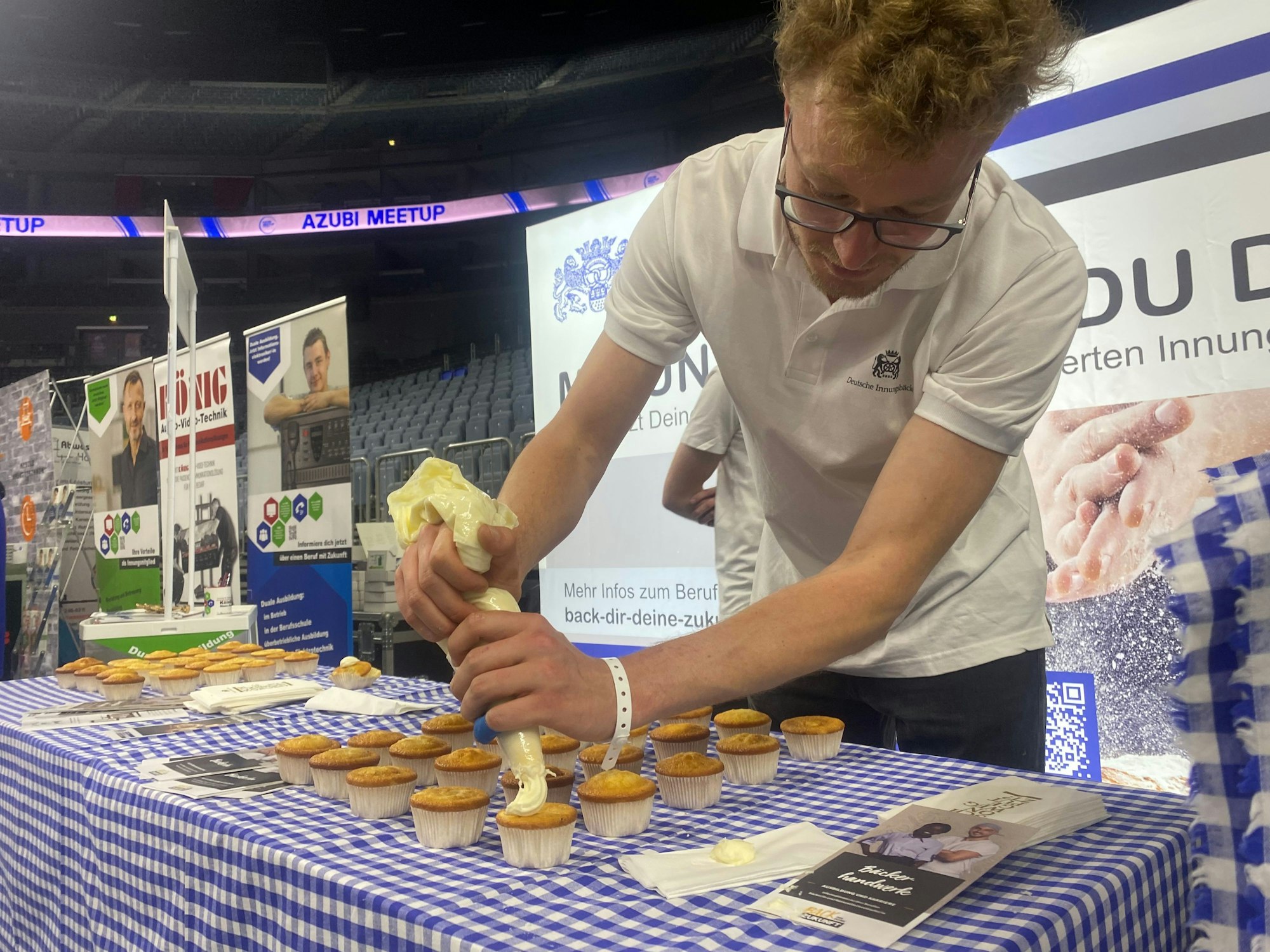 Ein Vertreter der Bäcker-Innung Buttercreme auf einen Muffin