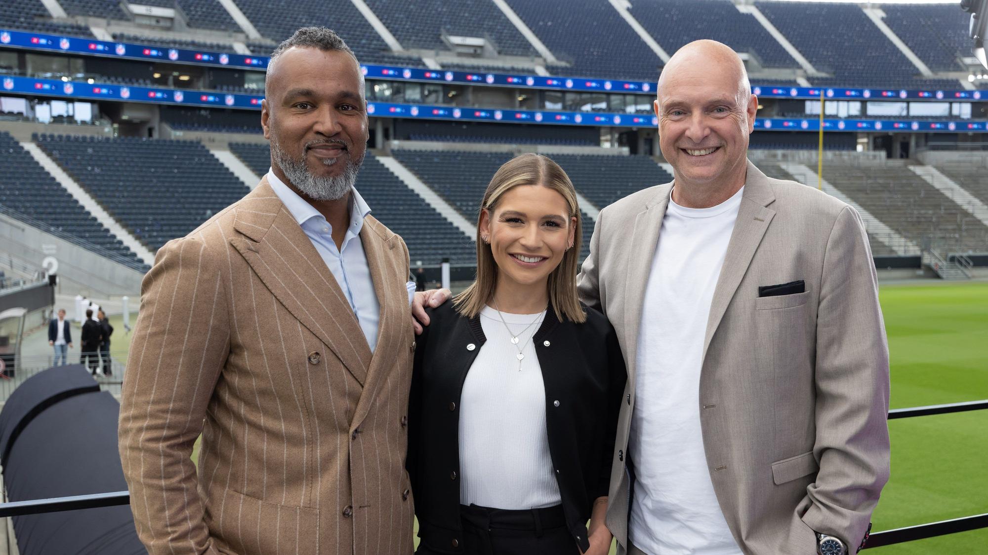 Frank Buschmann posiert mit Jana Wosnitza und Patrick Esume für ein Foto im Frankfurter Stadion.