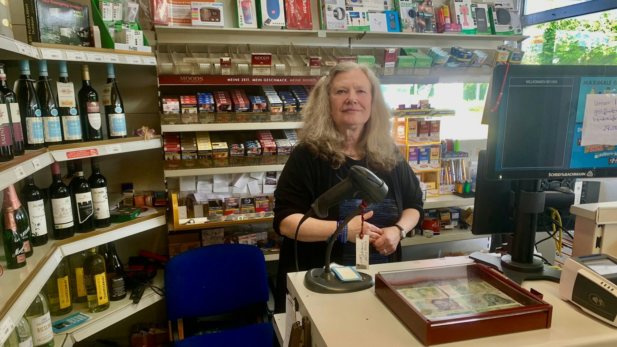 Frau Benz steht hinter der Kasse in der freien Tankstelle in Ossendorf.