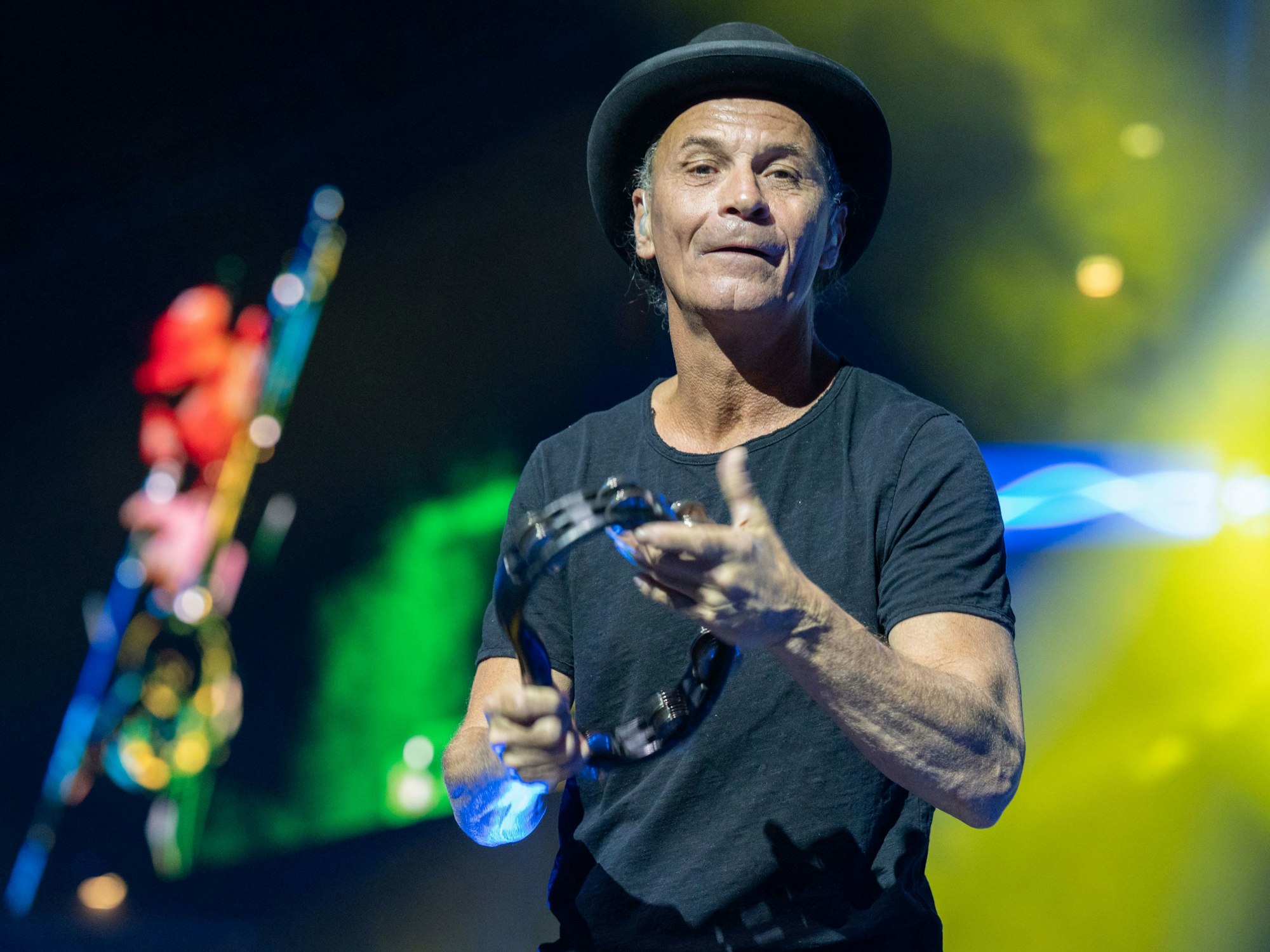 Peter Brings mit Hut auf der Bühne mit einem Instrument in der Hand.