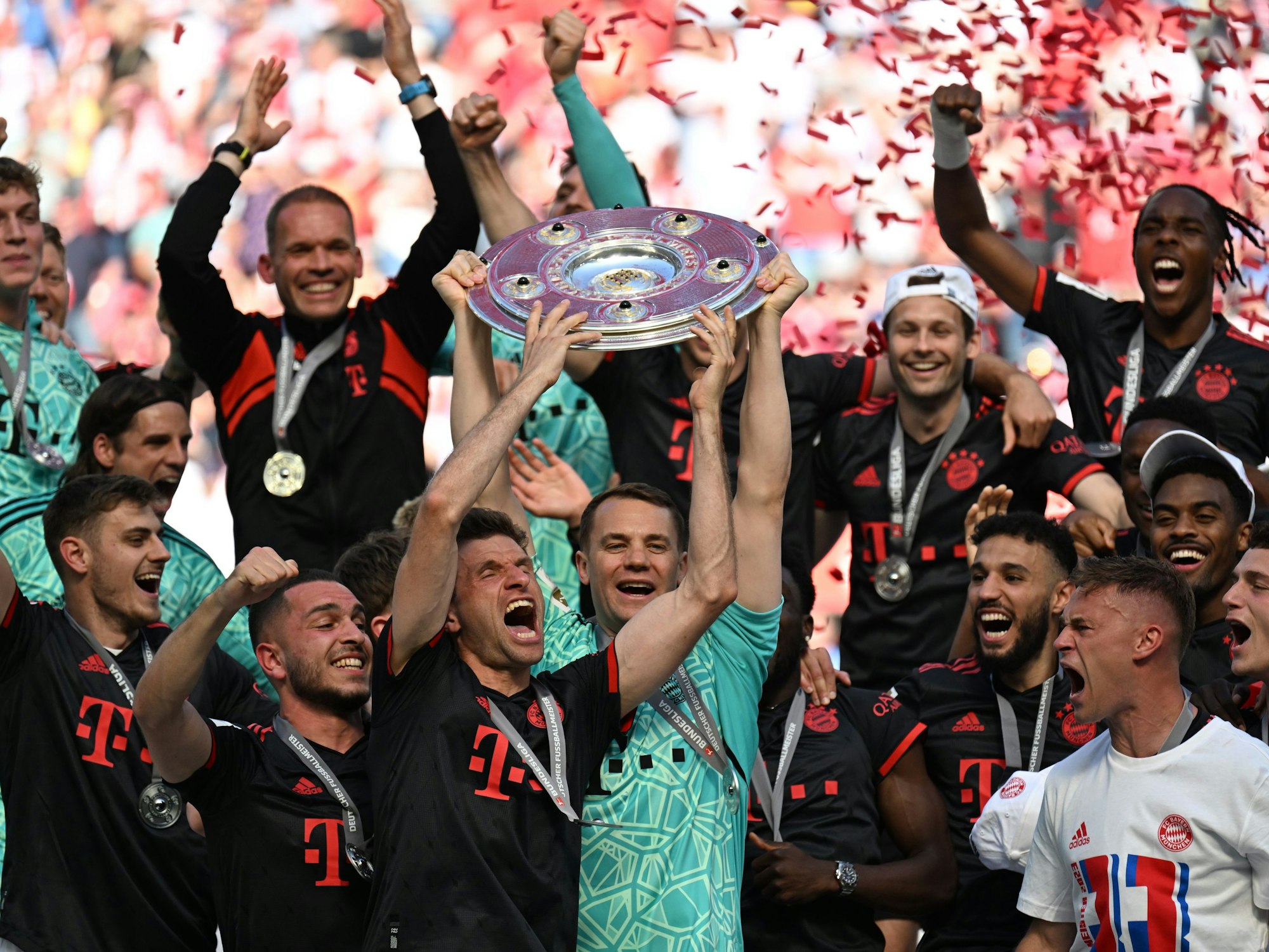 Bayerns Torhüter Manuel Neuer (M) hält die Meisterschale hoch.