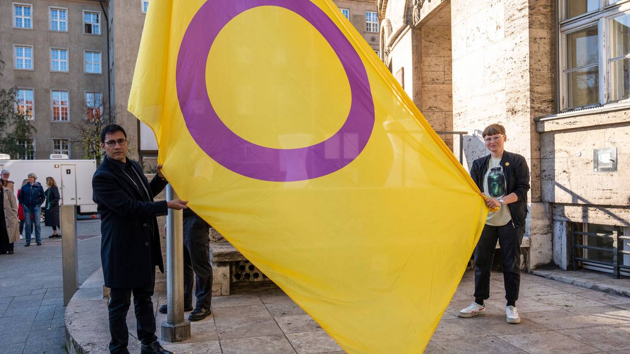 Zwei Personen halten eine gelb-lila Flagge