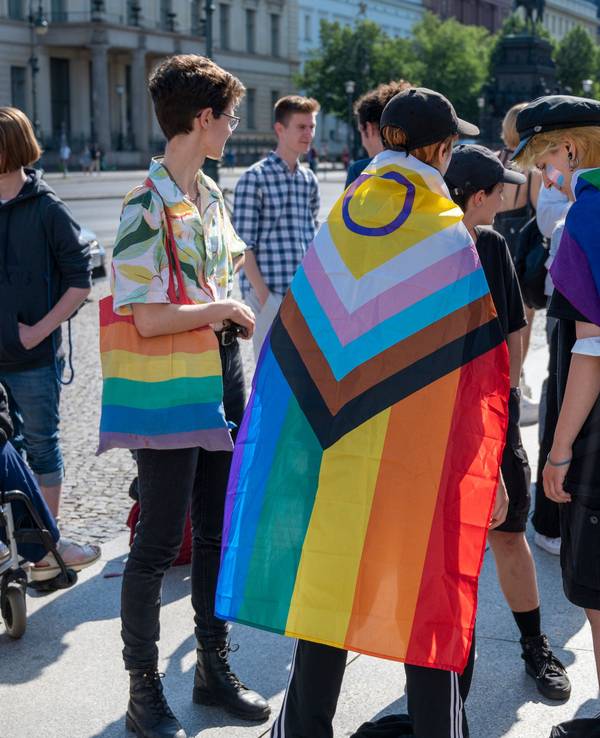 Mehrere Personen mit Regenbogenfahnen.