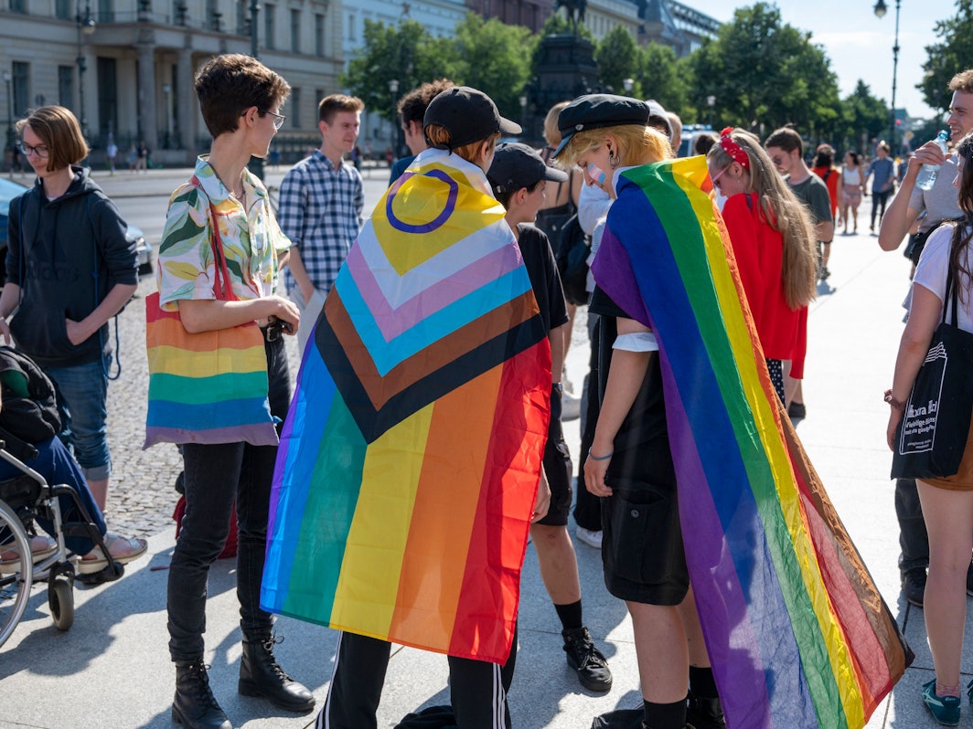 Mehrere Personen mit Regenbogenfahnen.